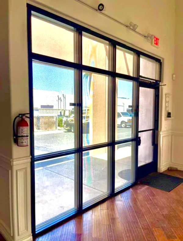 Commercial Storefront Security Screens for Doors and Windows — interior view of paired pedestrian doors with mesh sidelight in a Las Vegas business, by Olson Iron