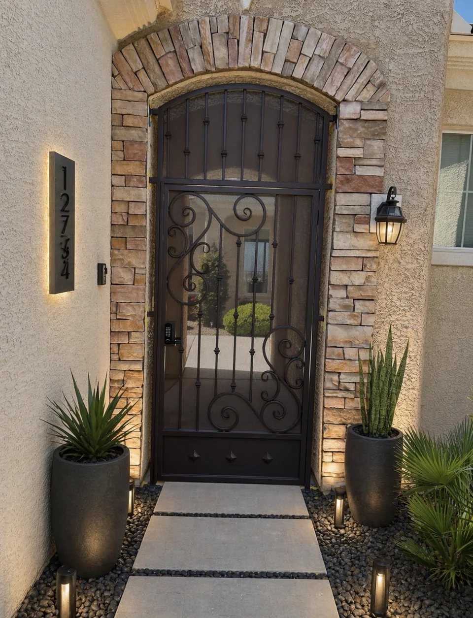 Olson Iron custom courtyard entry gate in Las Vegas — Custom scroll-iron entry gate with center medallion at Spanish-style stone home (810G)