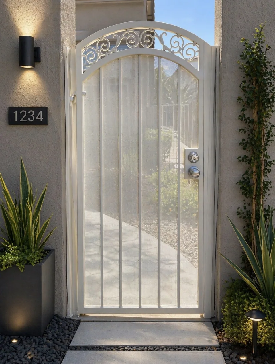 Olson Iron custom courtyard entry gate in Las Vegas — Mediterranean scroll iron entry gate at warm-tan stucco arch with potted topiary (813G)