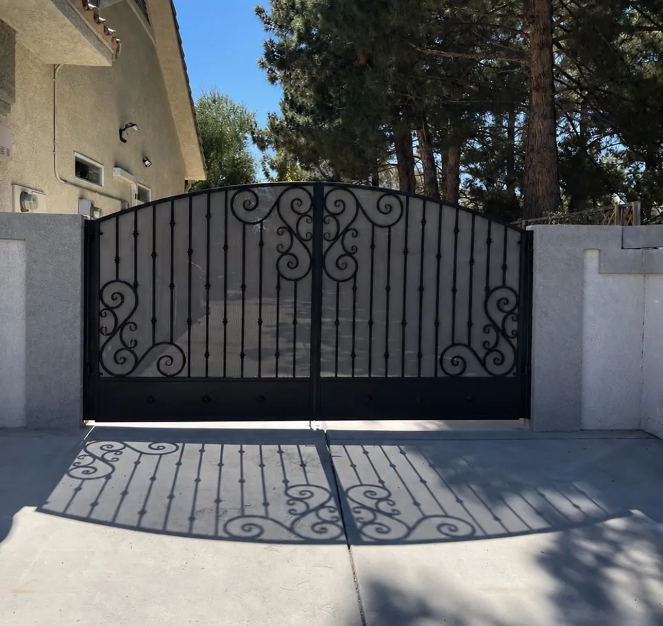 Olson Iron custom side-yard gate in Las Vegas — classic black scroll double driveway gate with decorative finials and paver apron in Las Vegas (711G)
