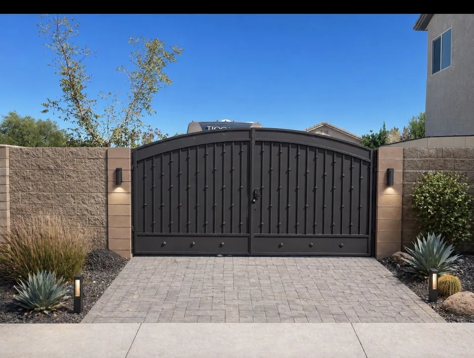 Olson Iron custom RV / driveway gate in Las Vegas — black double-swing rv gate with decorative rivets and arched top between stucco walls in Las Vegas (712G)