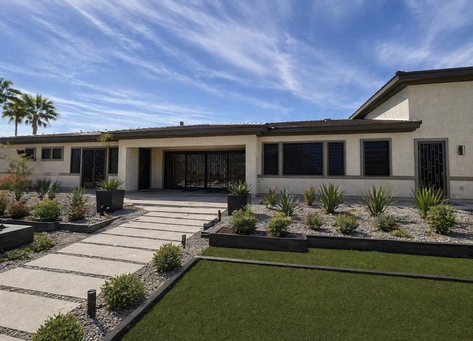 Modern Las Vegas home with custom Olson Iron solar security screens on windows and garage door — bright daylight showing the black mesh