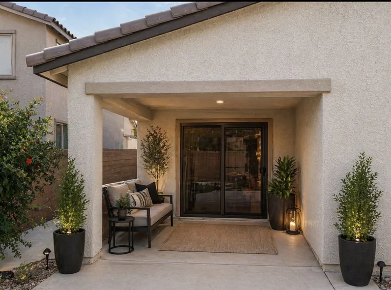 Olson Iron retractable patio slider screen on a covered Las Vegas patio entry, with lounge seating and planter columns (871Z)