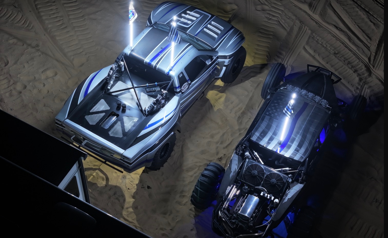 Two Olson Iron off-road vehicles parked at the dunes