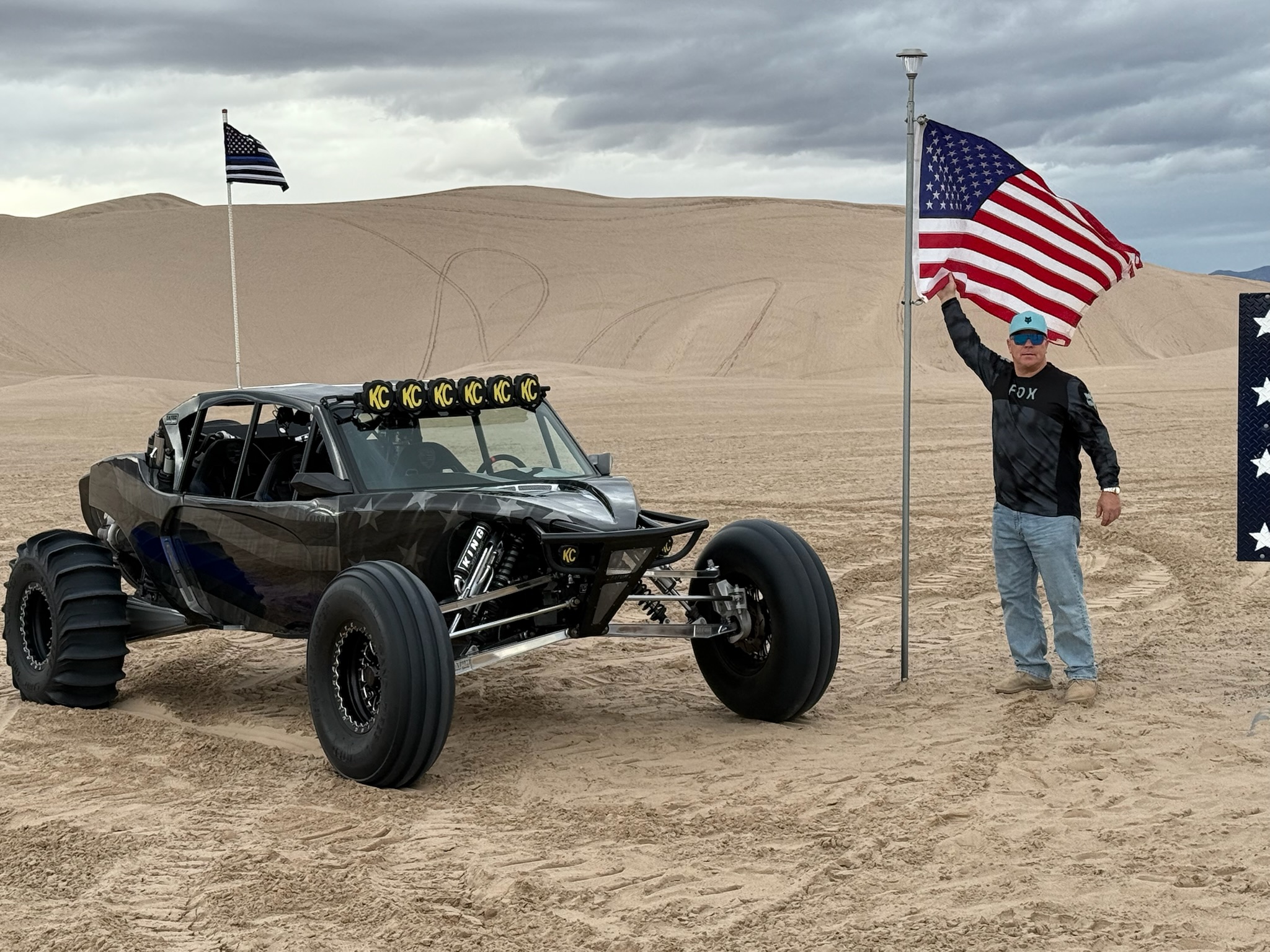 Bo Olson at the dunes holding an American flag