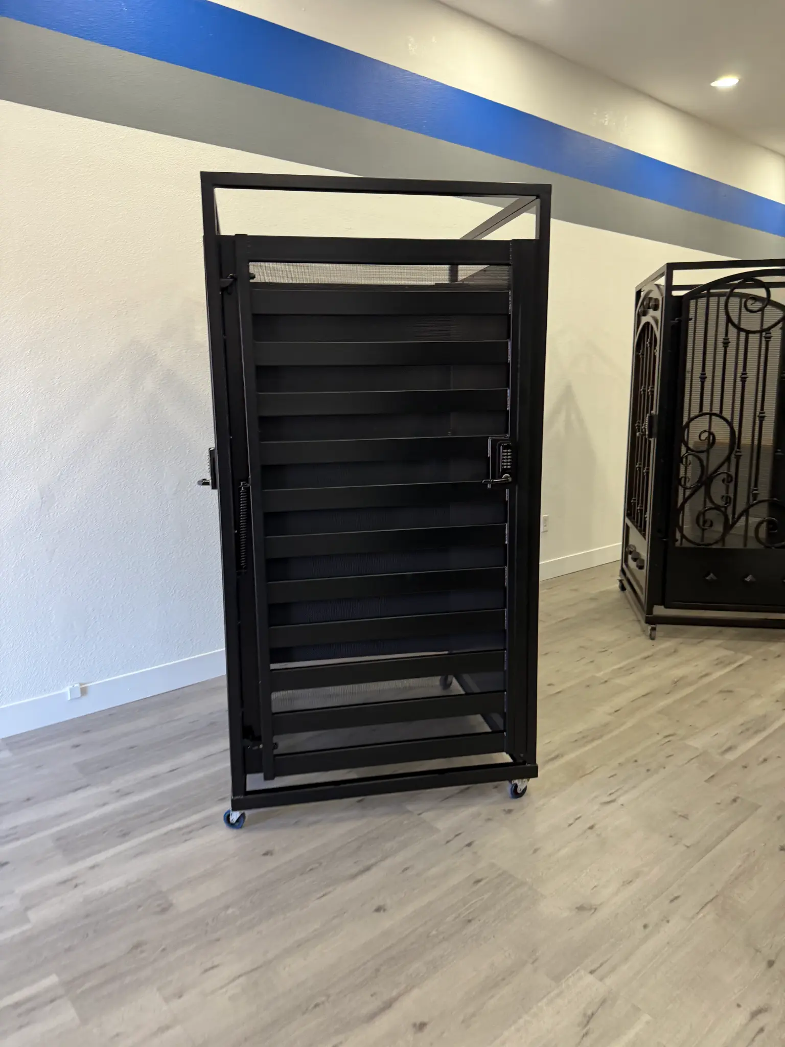 Black metal security gate with keypad lock on display in Olson Iron showroom