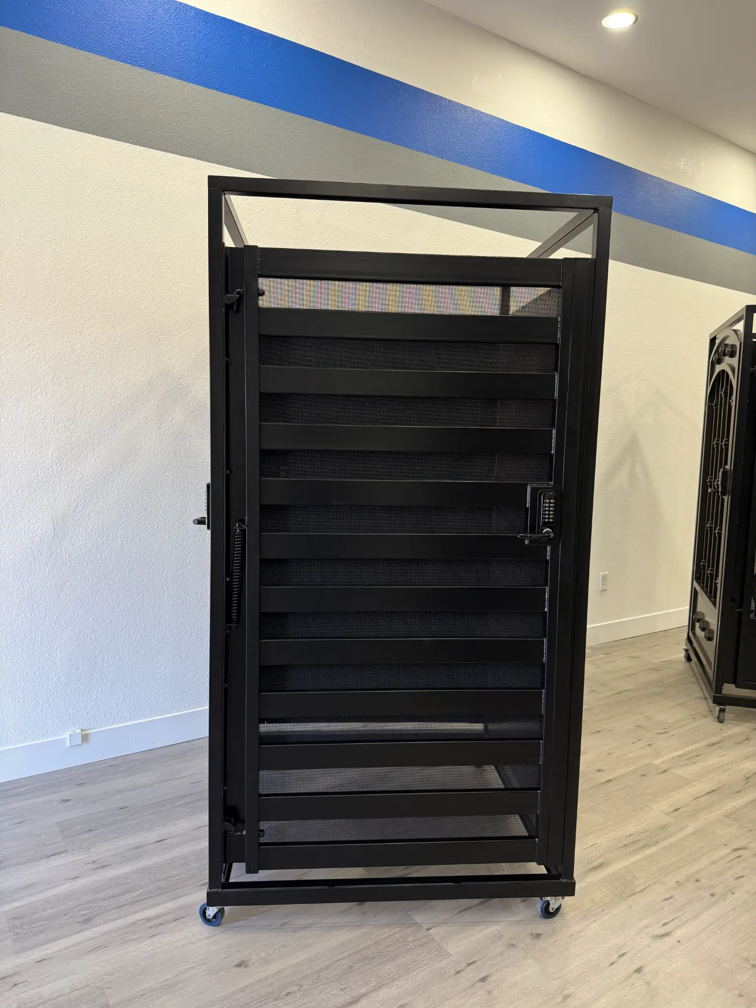 Black metal gate with horizontal slats and keypad on display in Olson Iron showroom