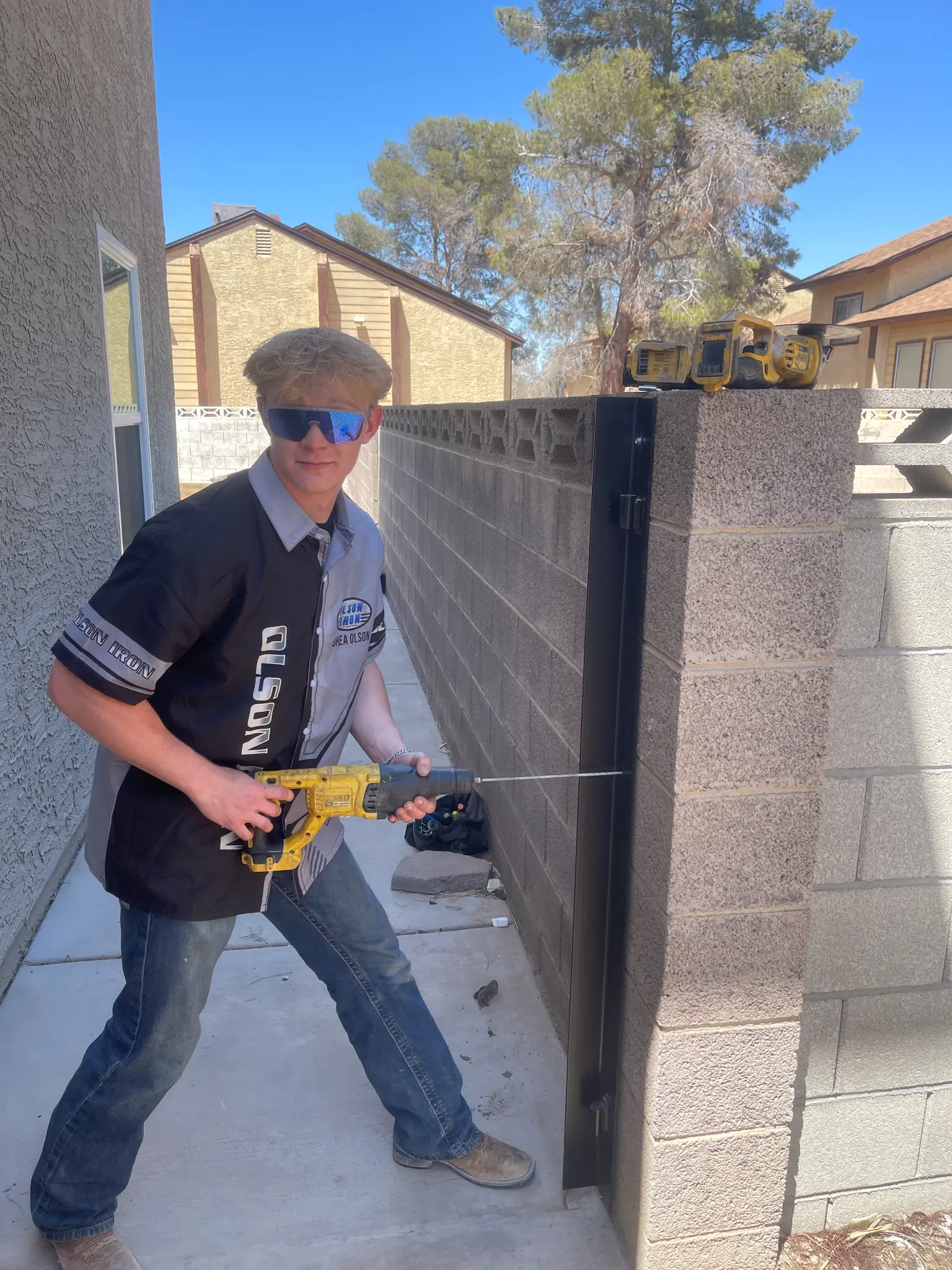Olson Iron crew member drilling a gate post on a Las Vegas job site